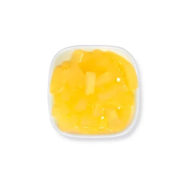 Peach-flavored coconut jelly cubes in syrup, golden color with fruity aroma, ideal for tea or juice toppings.