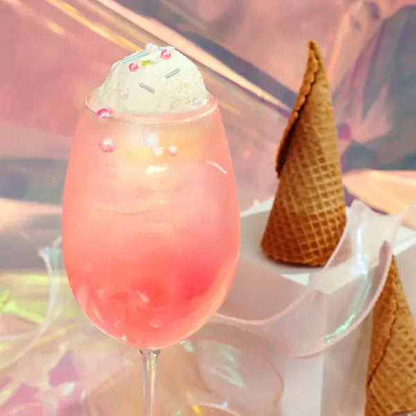 Lychee Syrup layered beverage with bright pink hue, creamy topping, and dessert-style presentation for café menus.