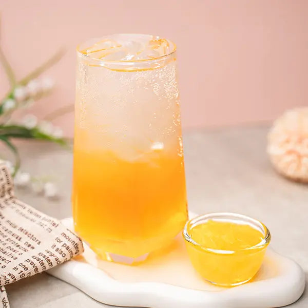 Peach Syrup beverage in a clear glass with ice, showing smooth texture and fruity layers for café and bubble tea drinks.