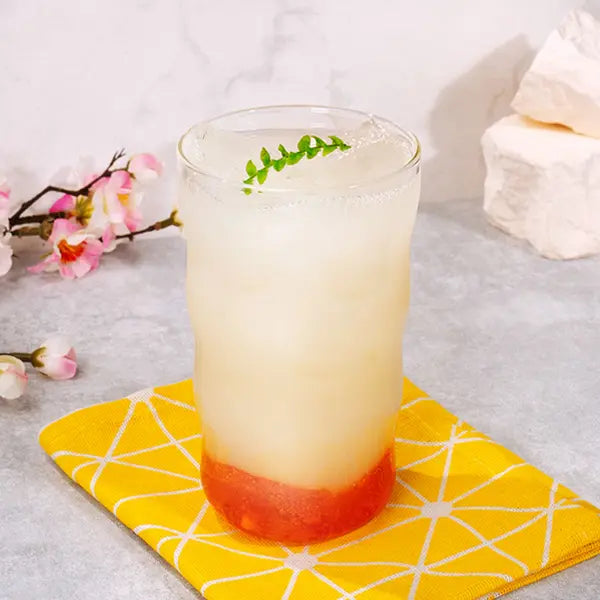 Refreshing yogurt drink made with yogurt syrup, layered with fruit puree and ice, served in a tall glass.