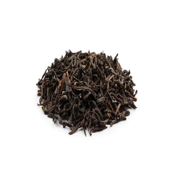 Dried Assam black tea leaves with twisted shape and dark reddish-brown tone.